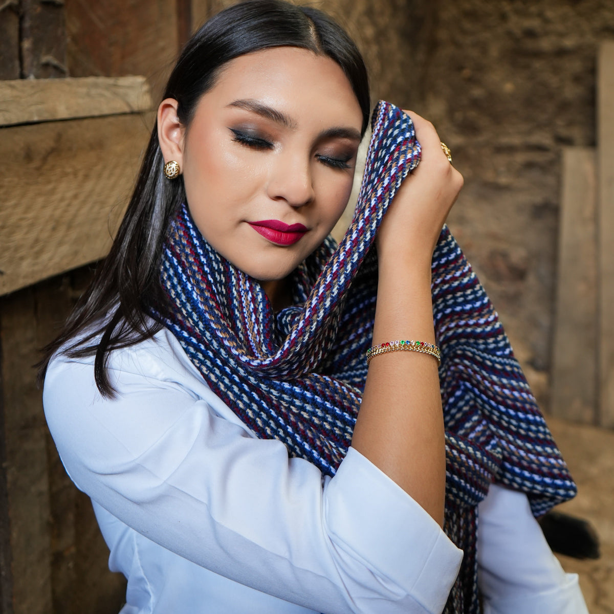 Navy and burgundy striped Ecuadorian scarf worn at the neck with a white blouse, Alennya.