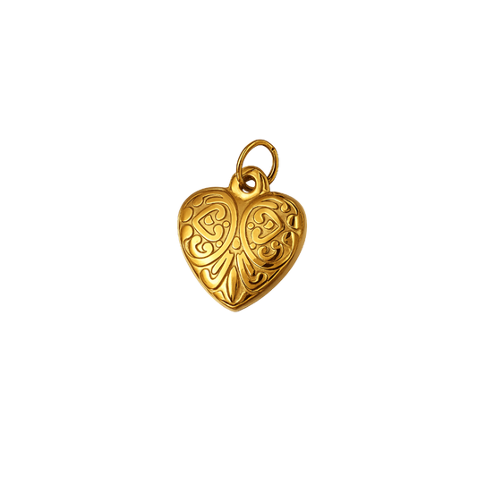 A gold heart-shaped pendant with intricate engraved scrollwork and a small top loop, shown on a plain white background.
