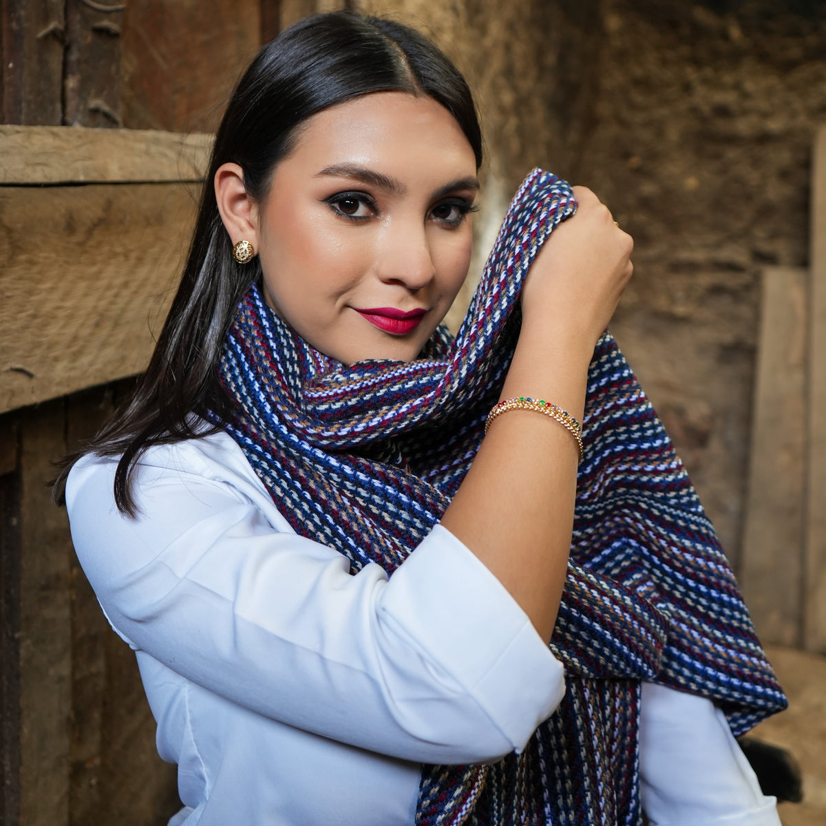 Navy and burgundy striped Ecuadorian scarf worn at the neck with a white blouse, Alennya.