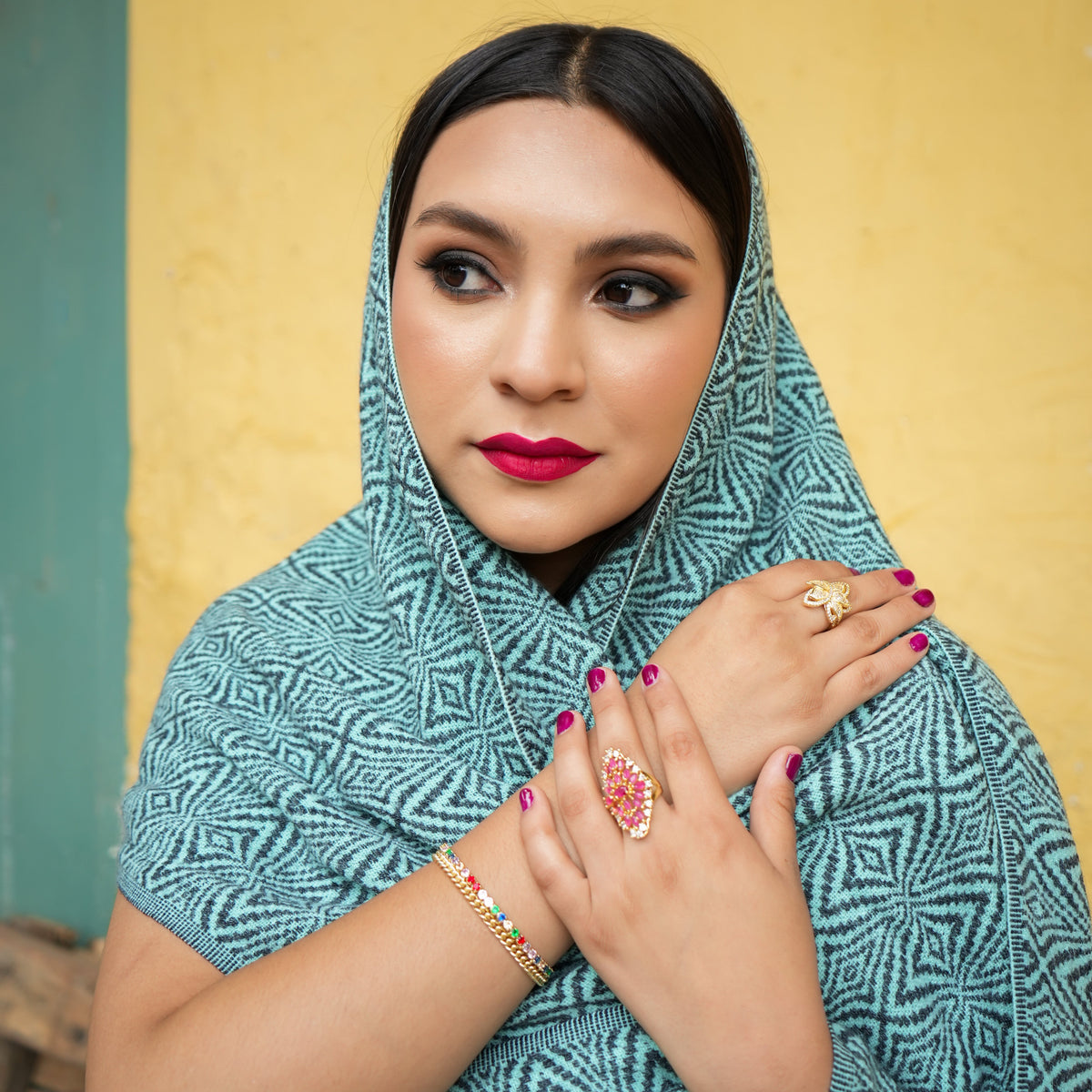 Turquoise and charcoal Ecuadorian alpaca scarf worn over the head and shoulders, Alennya.