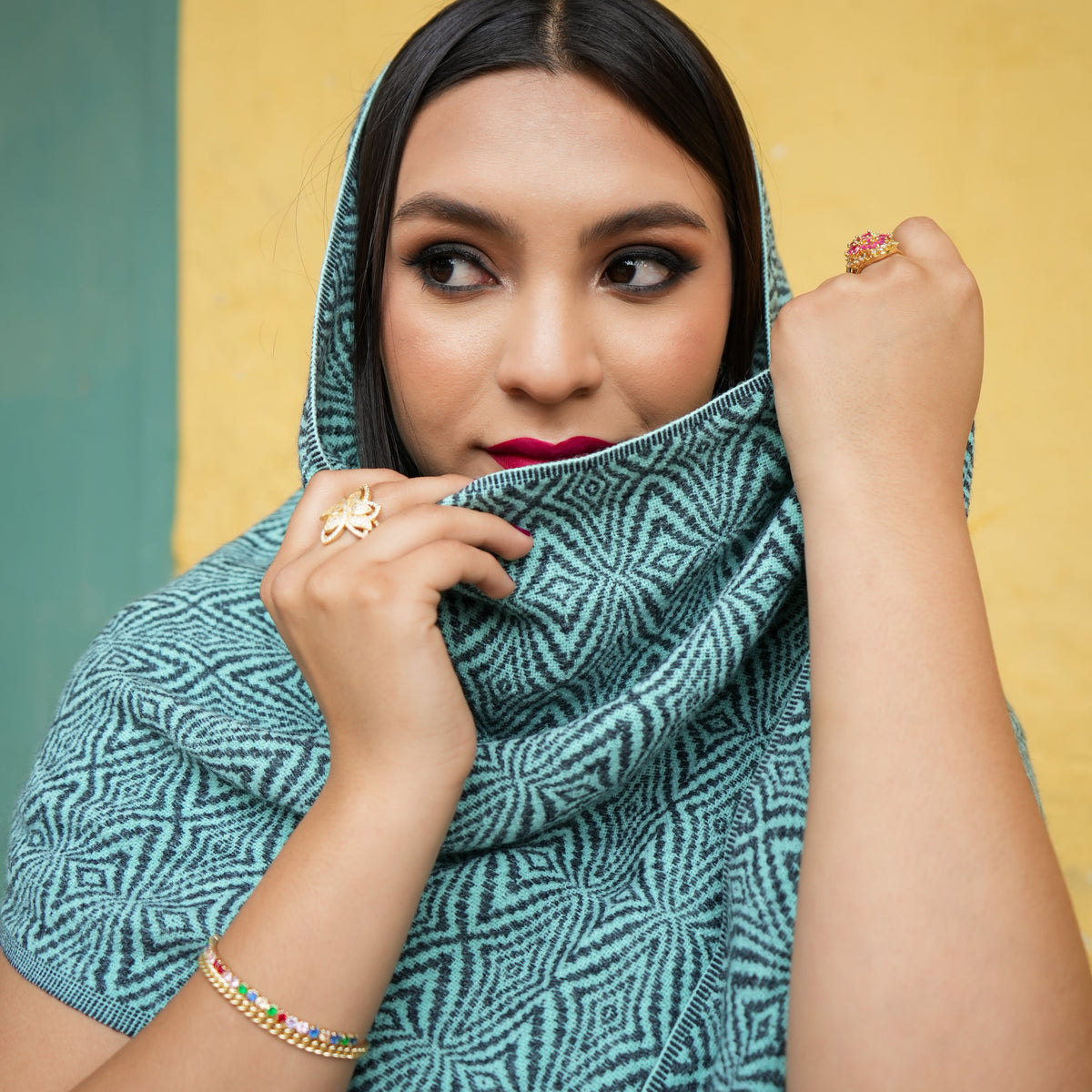 Turquoise and charcoal Ecuadorian alpaca scarf worn over the head and shoulders, Alennya.