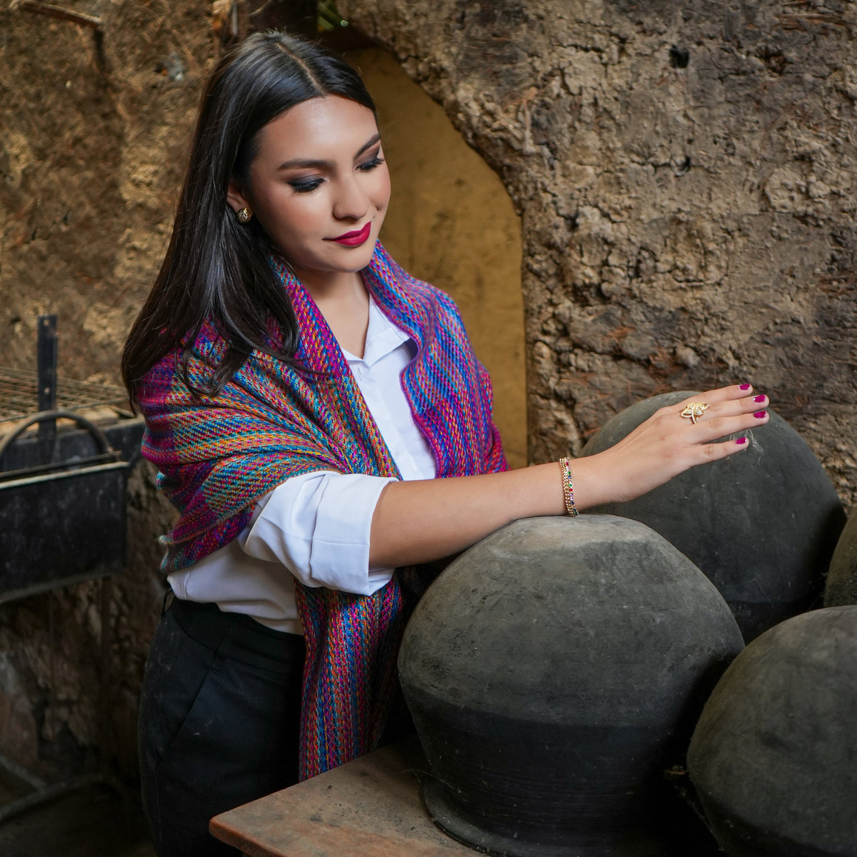 Woman wearing a multicolor Ecuadorian alpaca scarf draped over a white shirt, Alennya.