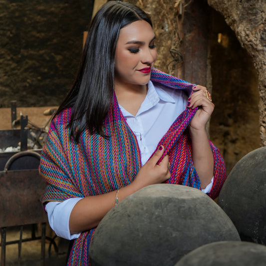 Woman wearing a multicolor Ecuadorian alpaca scarf draped over a white shirt, Alennya.