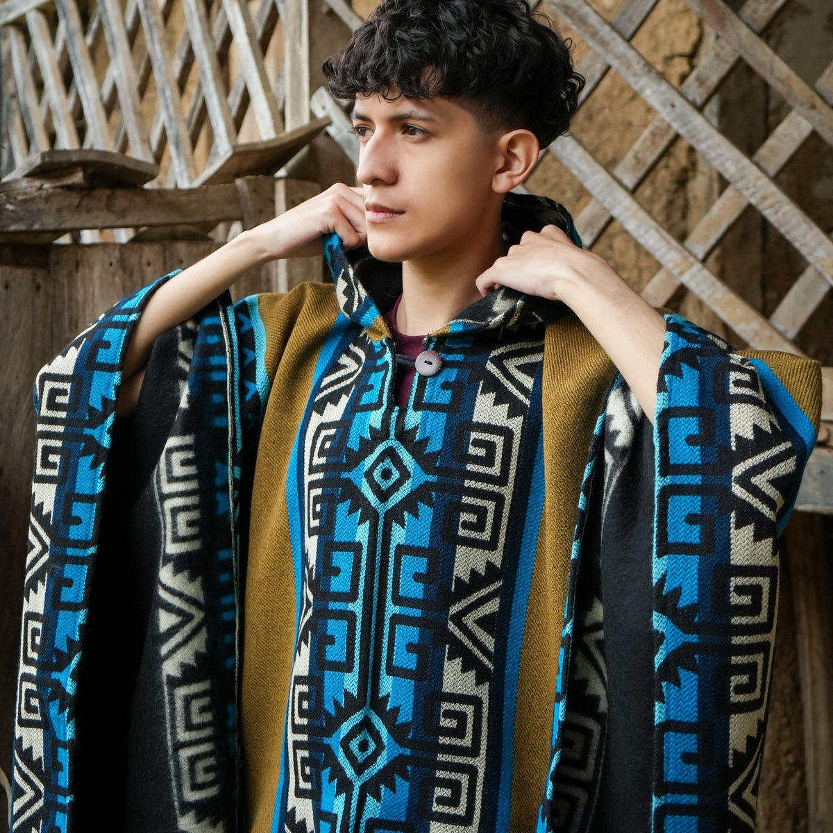 Turquoise and mustard Ecuadorian alpaca poncho with hood, worn outdoors, Alennya.