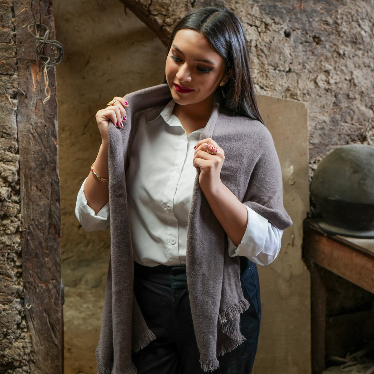 Taupe Ecuadorian alpaca scarf draped over the shoulders of a woman in a white shirt, Alennya.